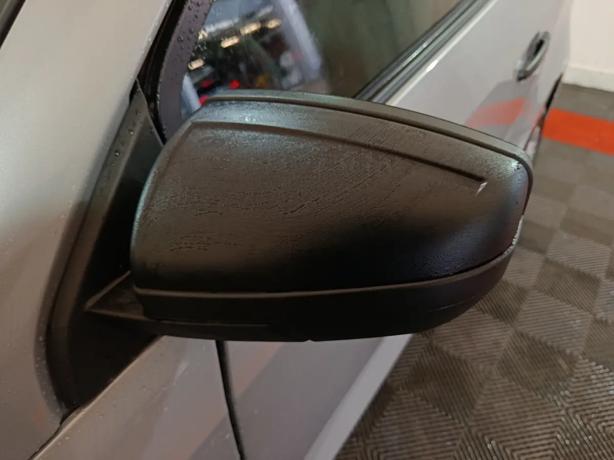 Gros plan sur le rétroviseur caméra côté gauche d’une Aixam Ambition gris clair 2026, vue latérale rapprochée.