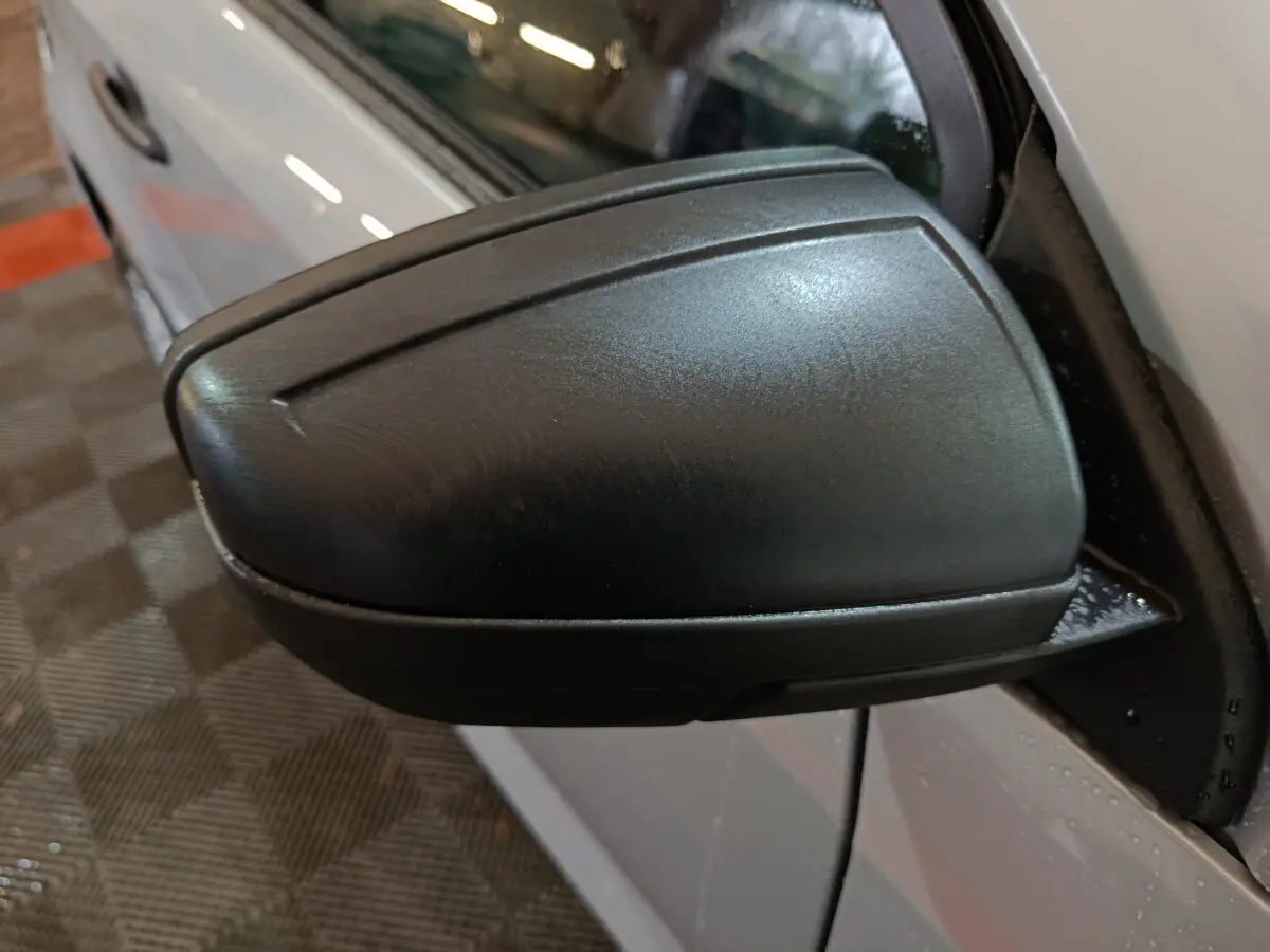 Gros plan sur le rétroviseur caméra côté conducteur d'une Aixam Ambition 0.5 City Pack gris clair, vue latérale gauche.