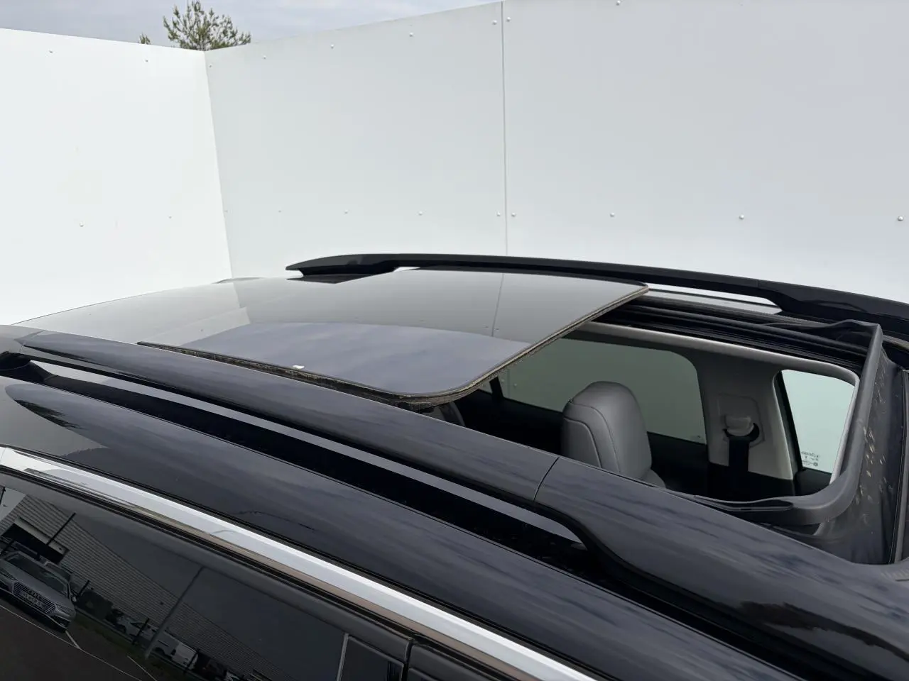 Toit ouvrant panoramique ouvert vu de dessus sur un Citroën C5 Aircross gris métal avec barres de toit noir brillant.