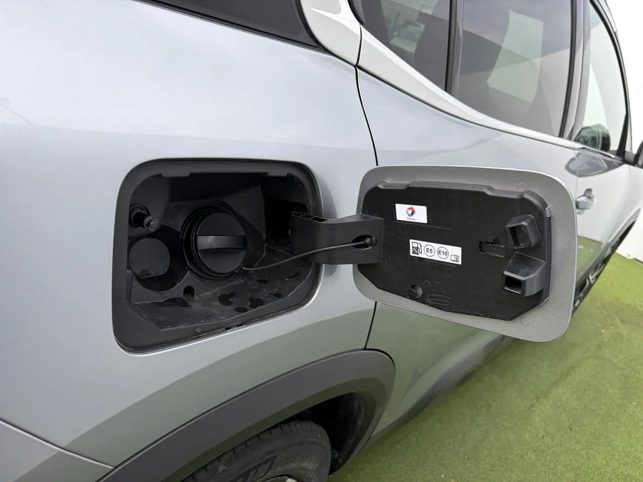 Vue rapprochée côté gauche sur la trappe d’essence ouverte d’un Citroën C5 Aircross gris métal 2024.