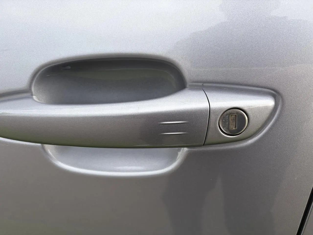 Poignée de porte gris métal en gros plan sur le côté gauche d'une Citroën C5 Aircross 2024 hybride.