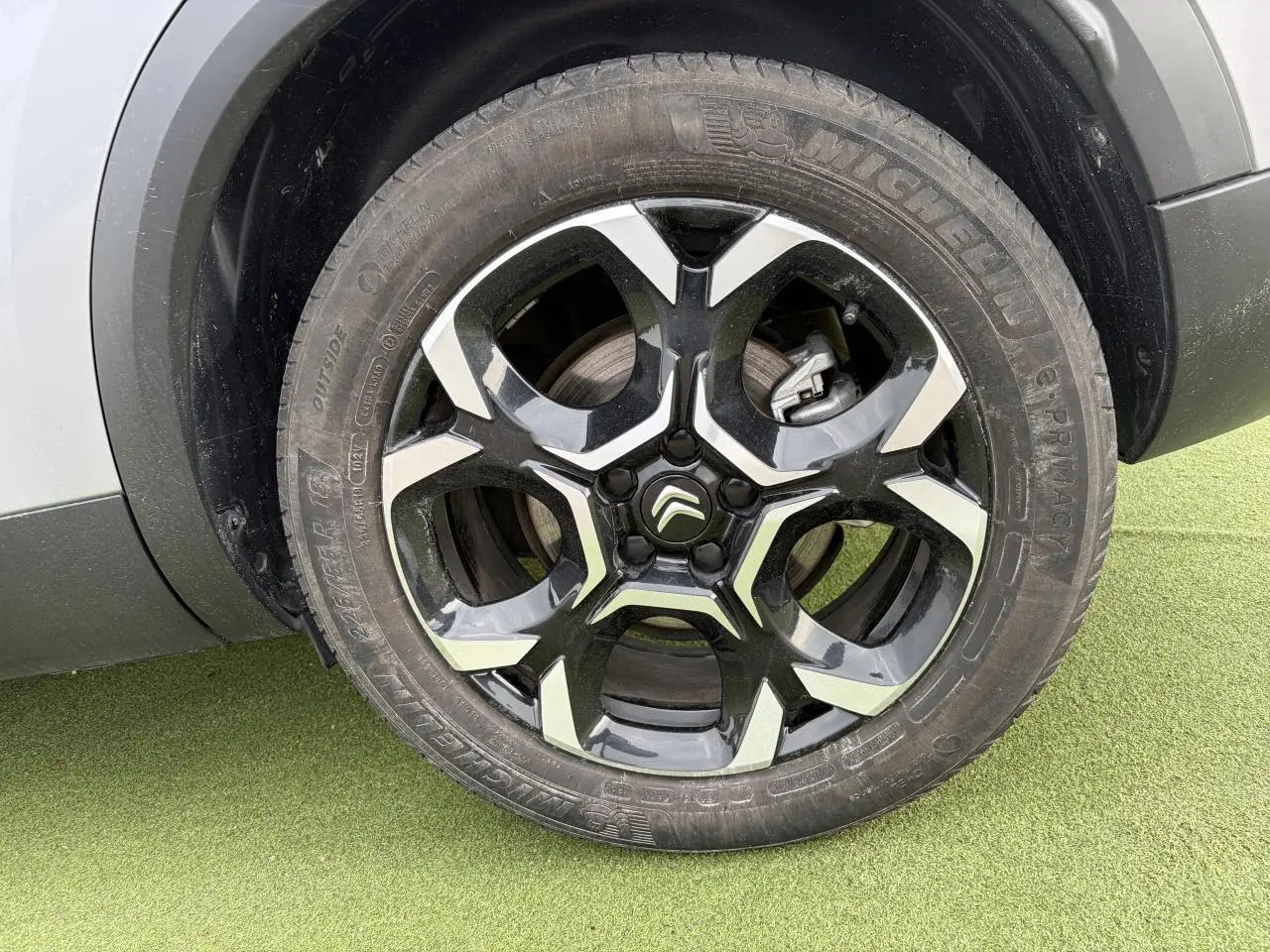 Gros plan sur la jante alliage 18'' bi-ton noir et argent du côté gauche d'un Citroën C5 Aircross gris métal.