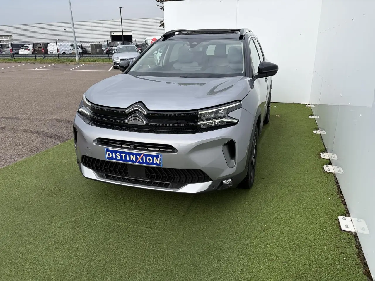 Citroën C5 Aircross gris métal en vue 3/4 avant droit avec toit panoramique noir et calandre noire brillante.
