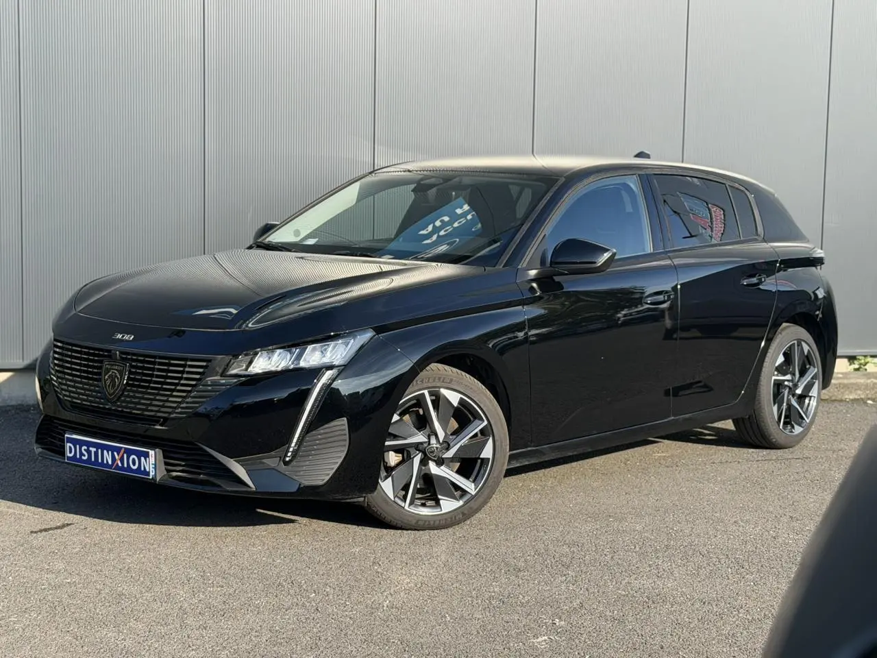 Peugeot 308 noir Perla vue 3/4 avant droit, avec jantes alliage 17'' Halong diamantées et signature lumineuse LED.