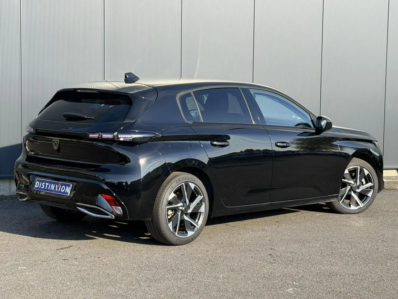 Peugeot 308 noir Perla vue 3/4 arrière droit, jantes alliage 17'' Halong diamantées et bandeau noir brillant arrière.