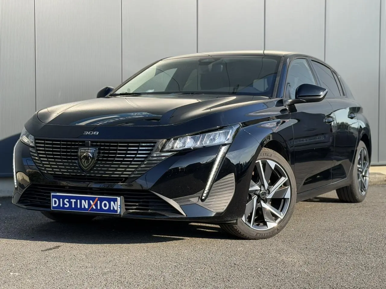 Peugeot 308 noir Perla vue 3/4 avant droit, avec calandre distinctive et jantes alliage 17 pouces.