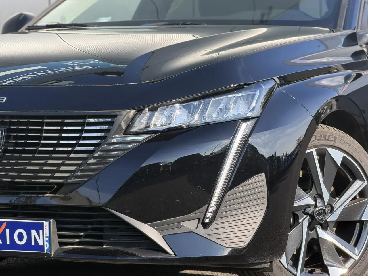 Vue avant droite d'une Peugeot 308 2025 noir Perla avec feux LED et jantes alliage 17 pouces diamantées.