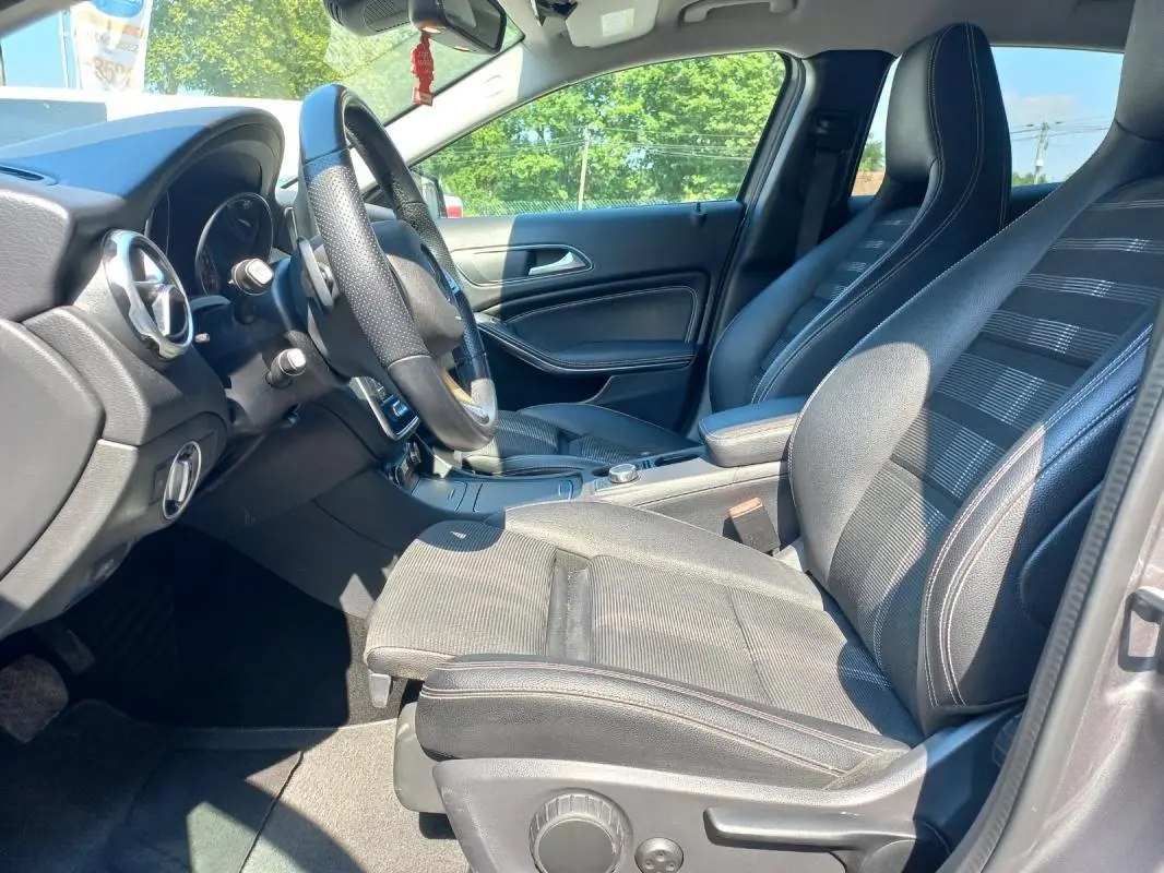 Intérieur de la Mercedes GLA 2019 en gris, vue côté conducteur montrant sièges sport et volant cuir perforé.