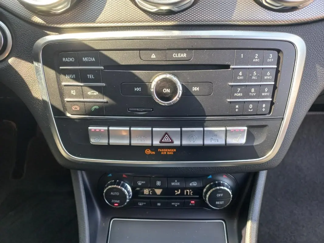 Vue rapprochée du tableau de bord de la Mercedes GLA 2019 gris, montrant la console centrale avec commandes multimédia et climatisation.