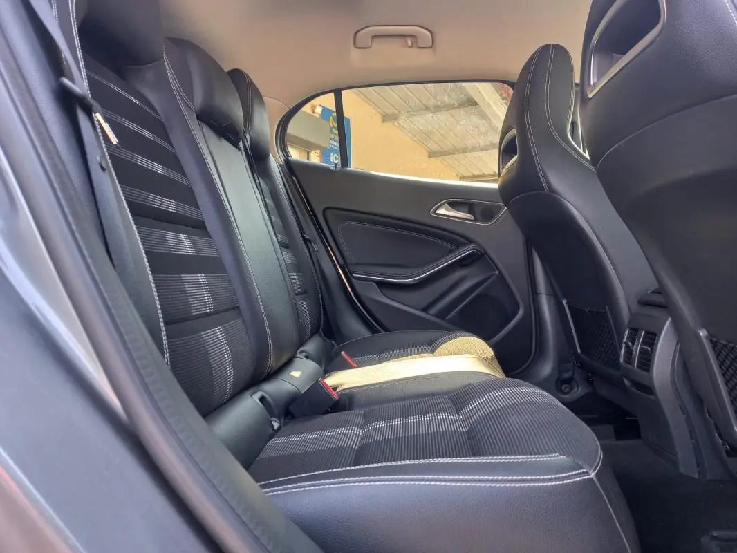 Vue intérieure arrière côté droit du Mercedes GLA 2019, sièges noirs avec surpiqûres blanches et tissu à motifs.