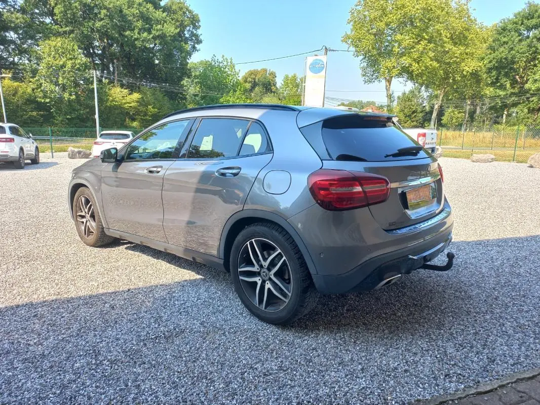 Mercedes GLA 2019 gris en 3/4 arrière droit, avec jantes alliage et attelage visible sur parking extérieur.
