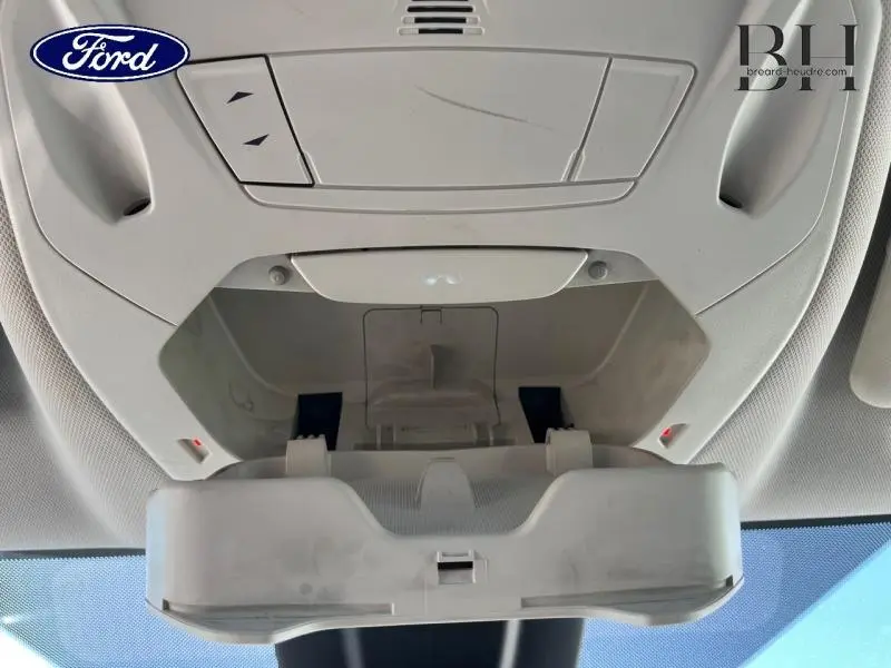 Vue en contre-plongée du compartiment lunettes ouvert dans le plafond intérieur du Ford Grand C-MAX blanc Glacier.