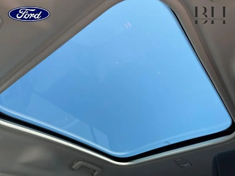 Toit panoramique fixe athermique vu de l'intérieur du Ford Grand C-MAX blanc Glacier, avec ciel bleu visible à travers.