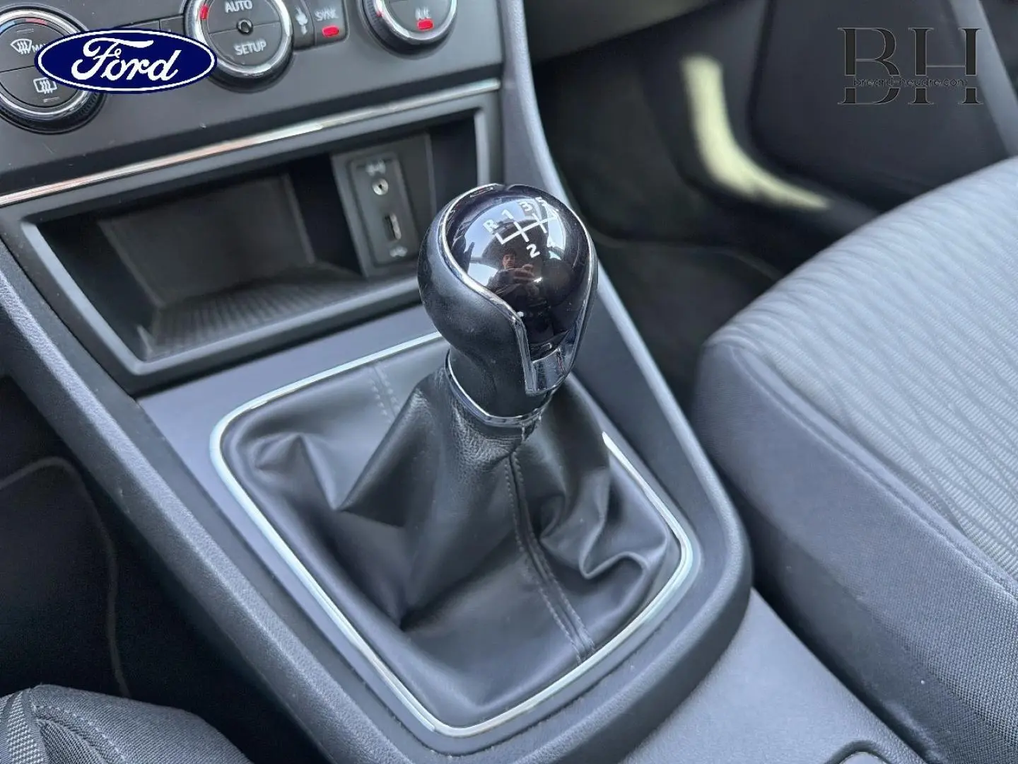 Gros plan sur le levier de vitesse manuel en cuir noir de la SEAT LEON ST 2017, intérieur gris et console centrale visible.
