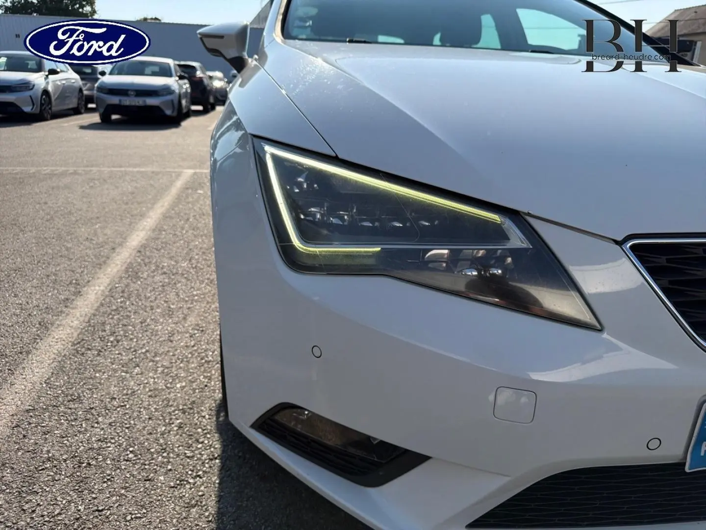 Gros plan sur le phare avant gauche d’une SEAT LEON ST blanc Candy, mettant en valeur son design LED anguleux.