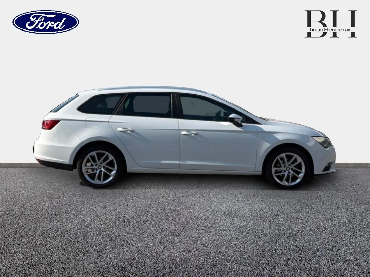 Profil côté gauche d'une SEAT LEON ST blanche Candy de 2017 avec jantes alliage et vitres teintées.