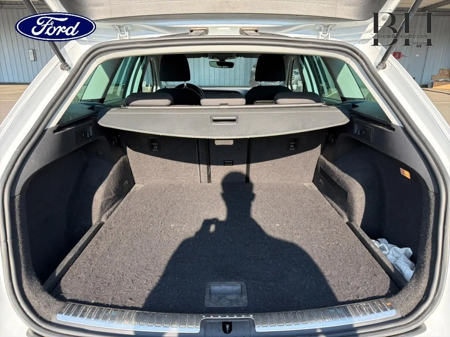 Coffre ouvert vu de l'arrière d'un SEAT LEON ST blanc Candy, montrant un espace de chargement vide avec cache-bagages.
