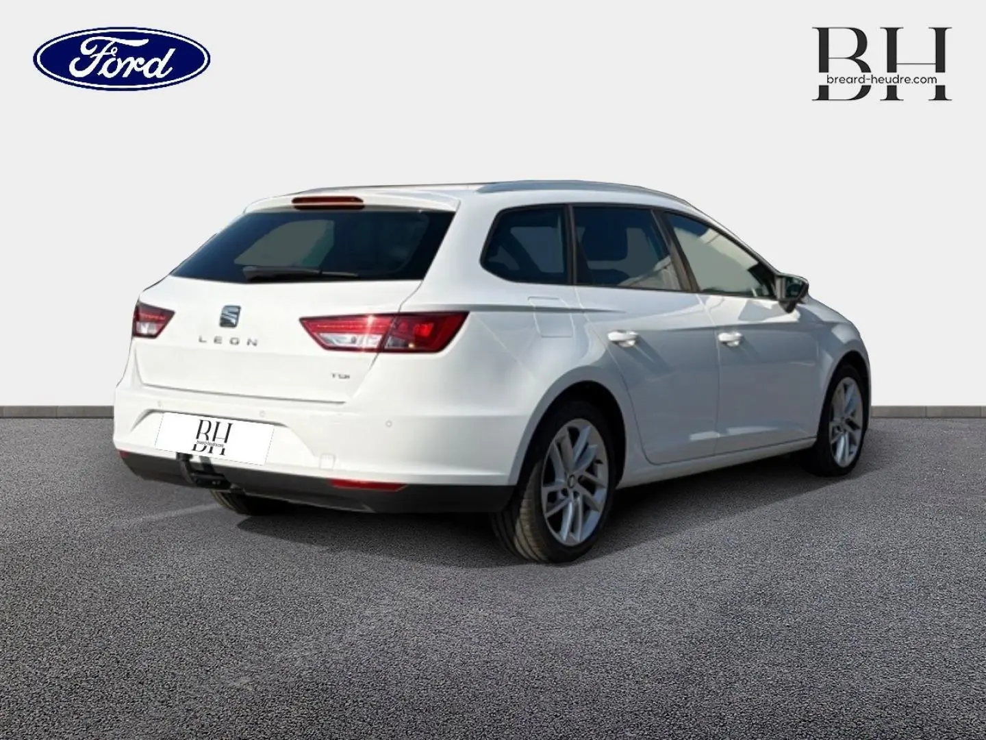 SEAT Leon ST blanc Candy vue 3/4 arrière droit avec crochet d'attelage et jantes alliage visibles.