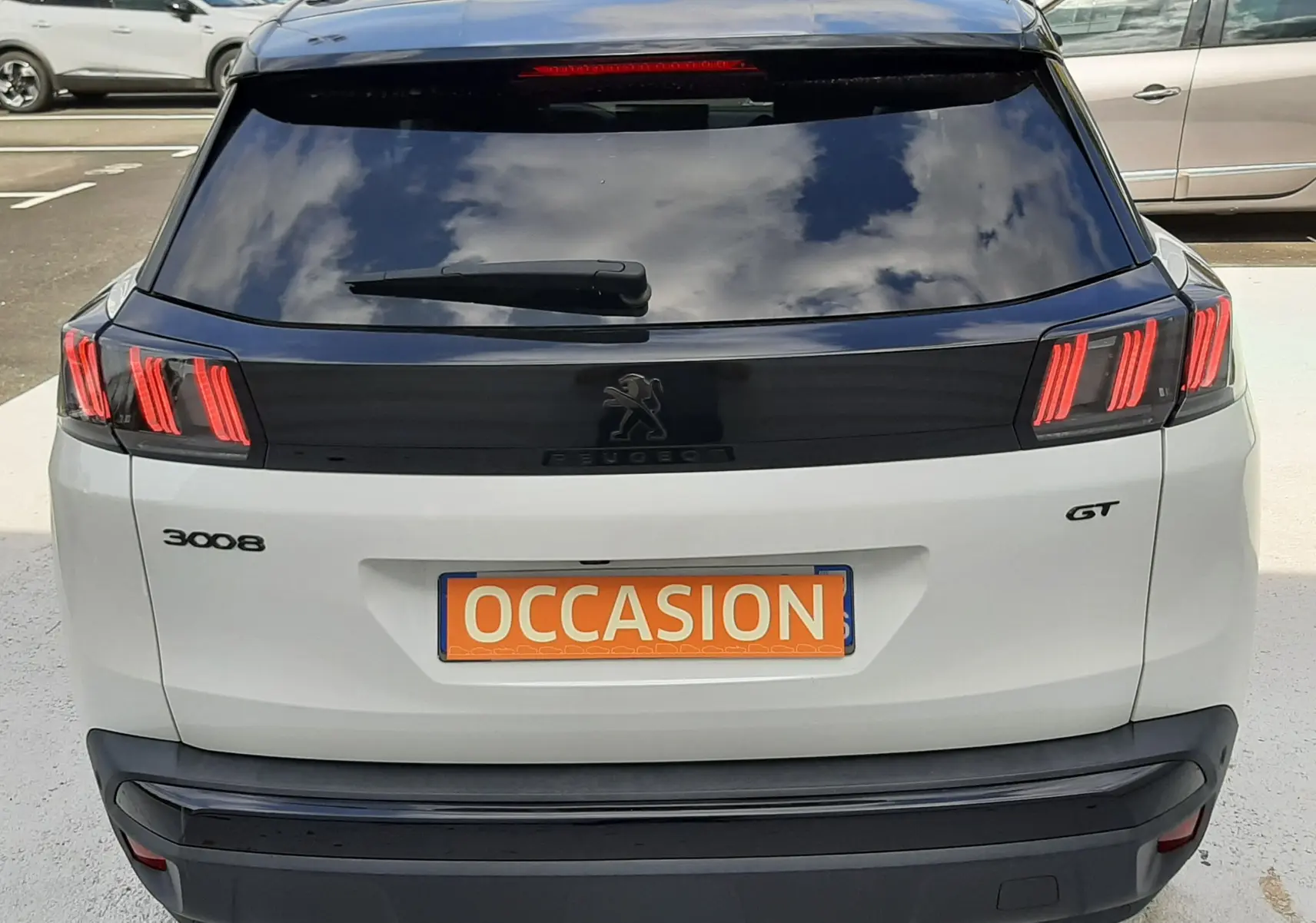 Vue arrière d'un Peugeot 3008 GT blanc nacré avec toit noir, feux arrière LED distinctifs et plaque "OCCASION".
