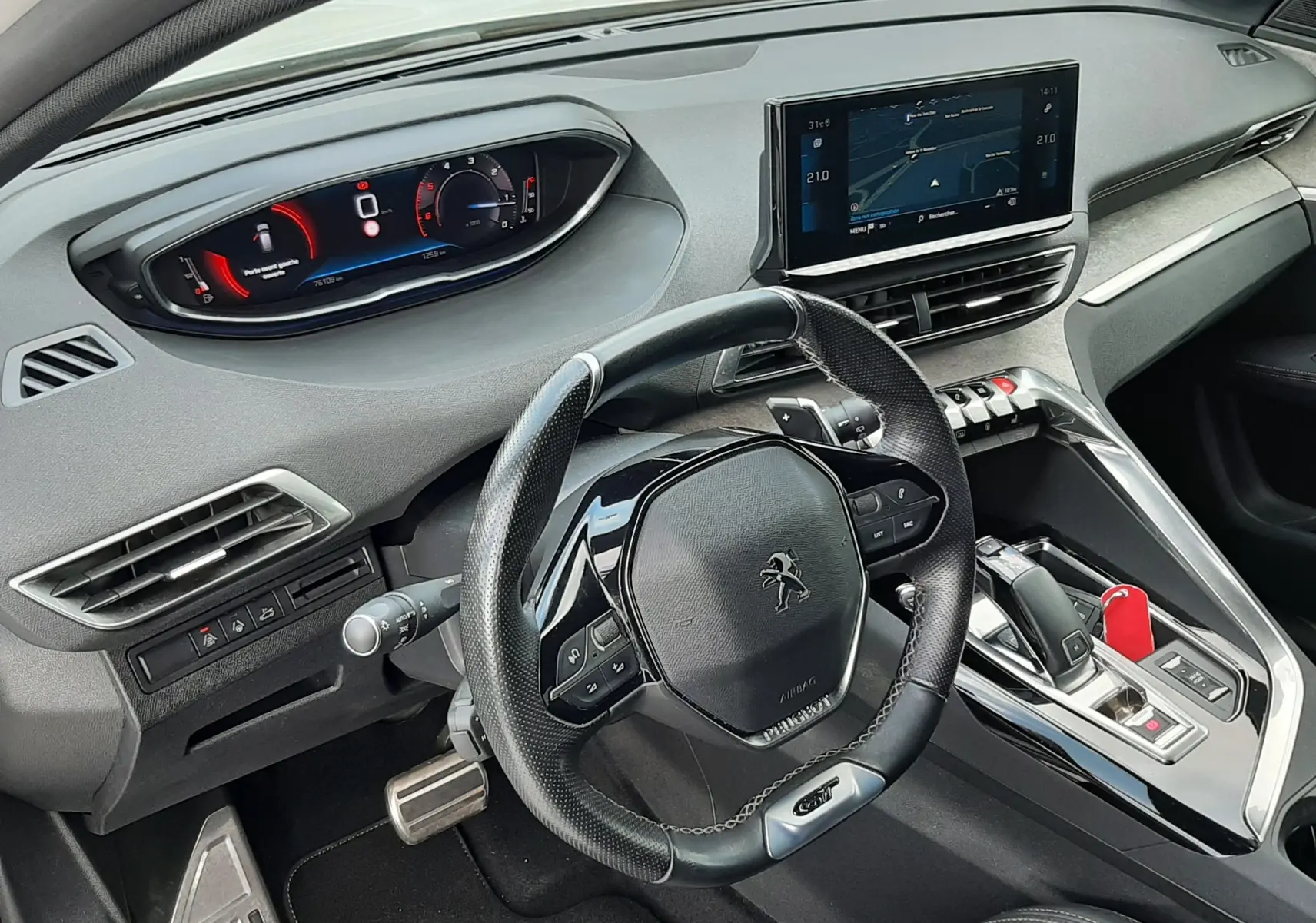 Vue intérieure côté conducteur du Peugeot 3008 2022, volant compact, tableau de bord numérique et écran central tactile.