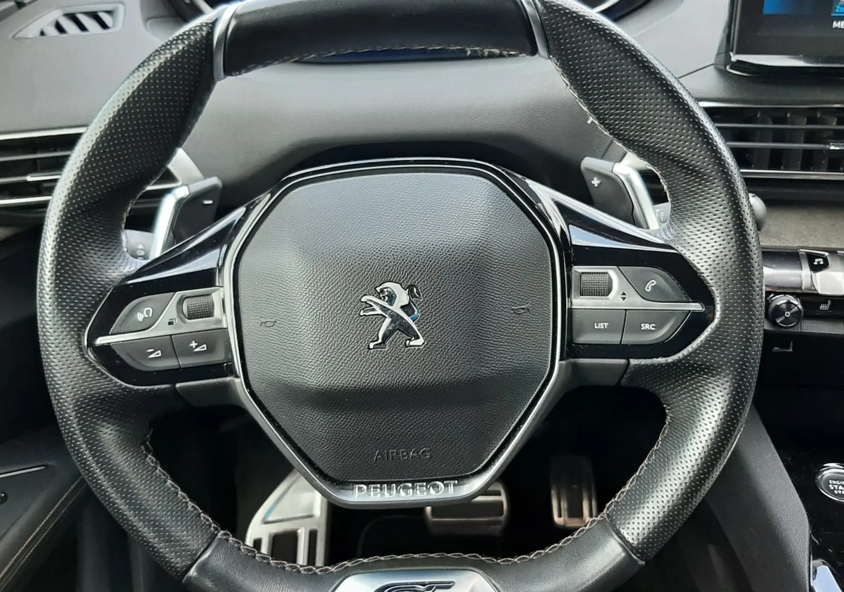 Vue rapprochée du volant cuir perforé noir avec logo Peugeot et badge GT du Peugeot 3008 1.5 BlueHDi 2022.