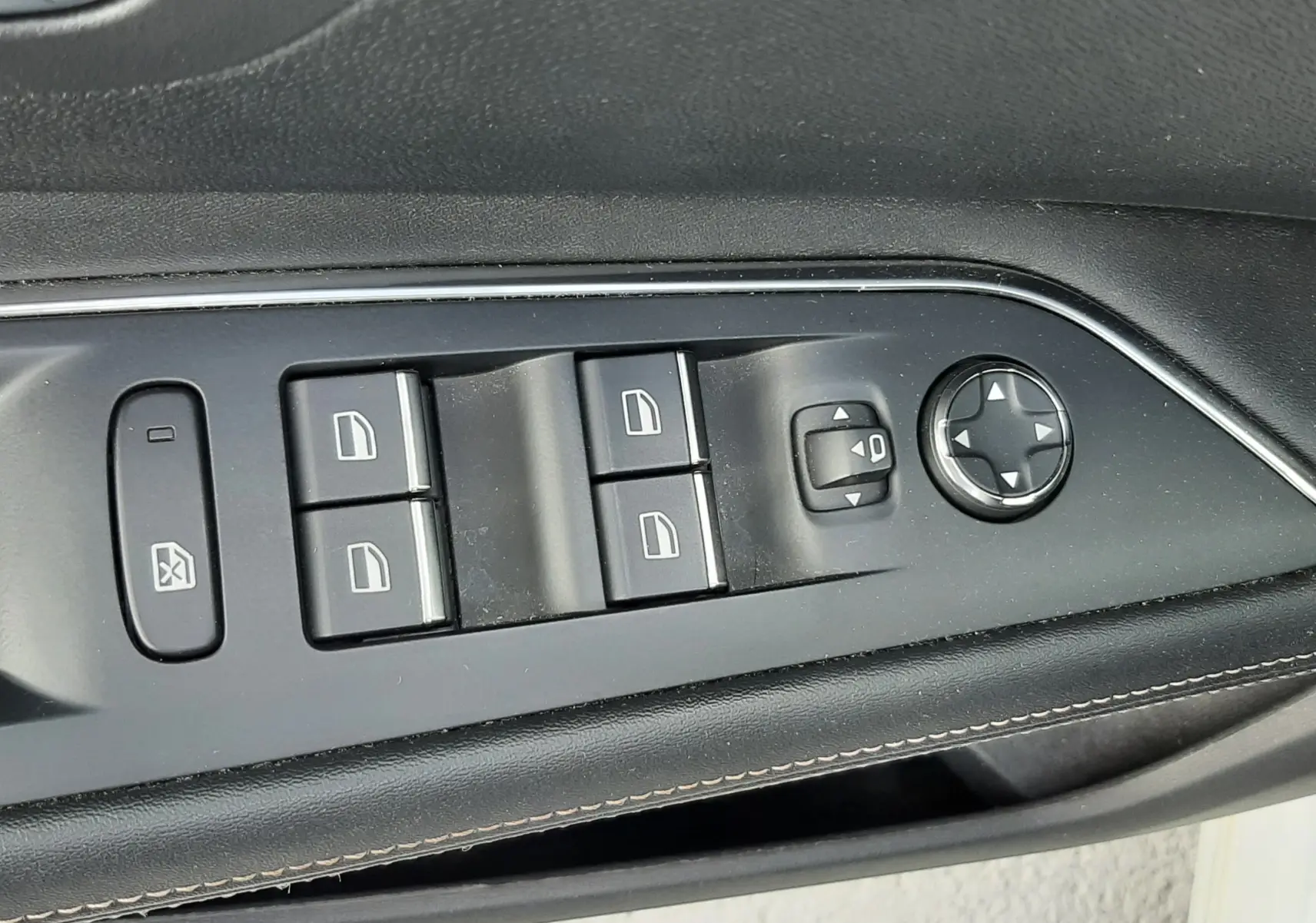 Vue rapprochée des commandes de lève-vitres et réglage des rétroviseurs sur la porte côté conducteur d’un Peugeot 3008 blanc nacré.