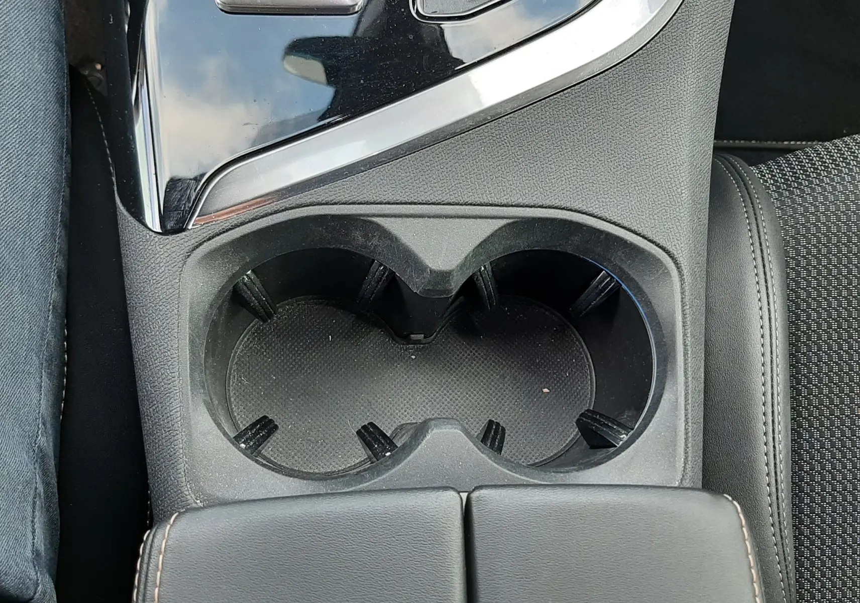 Vue en plongée sur la console centrale noire du Peugeot 3008 avec porte-gobelets et commandes de boîte automatique.