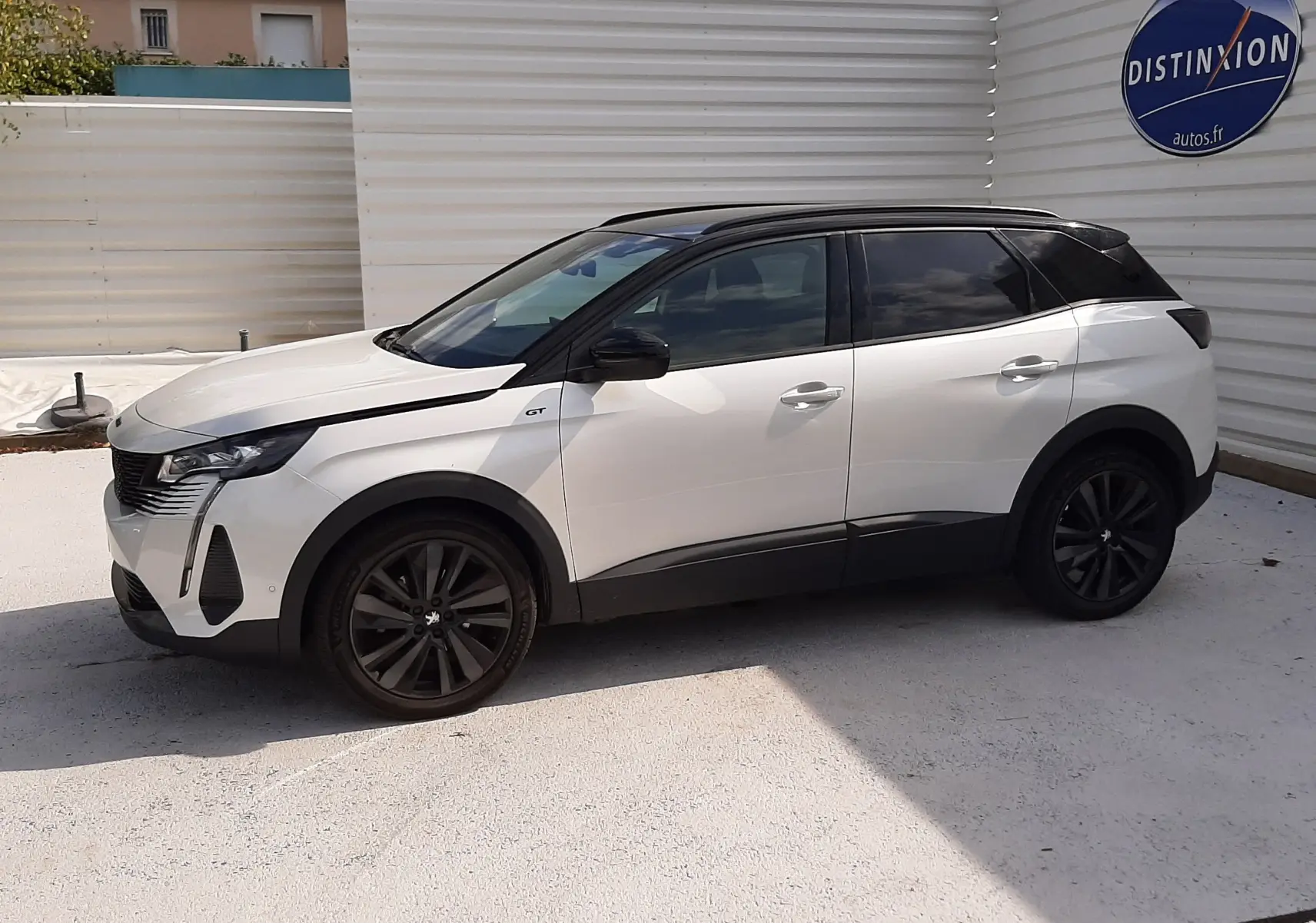 Peugeot 3008 blanc nacré avec toit noir, vue de profil côté gauche, jantes noires et badge GT visible.