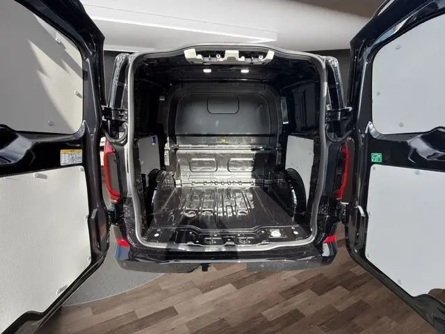 Vue arrière ouverte du Volkswagen Transporter noir 2026, montrant l'espace de chargement vide et la cloison pleine.