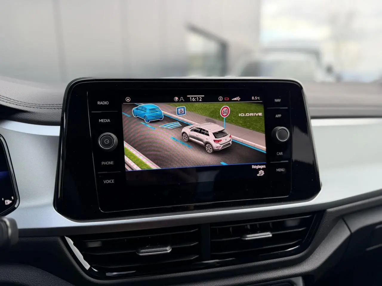 Écran tactile du tableau de bord du Volkswagen T-Roc 2025 affichant l'assistance à la conduite en ville.