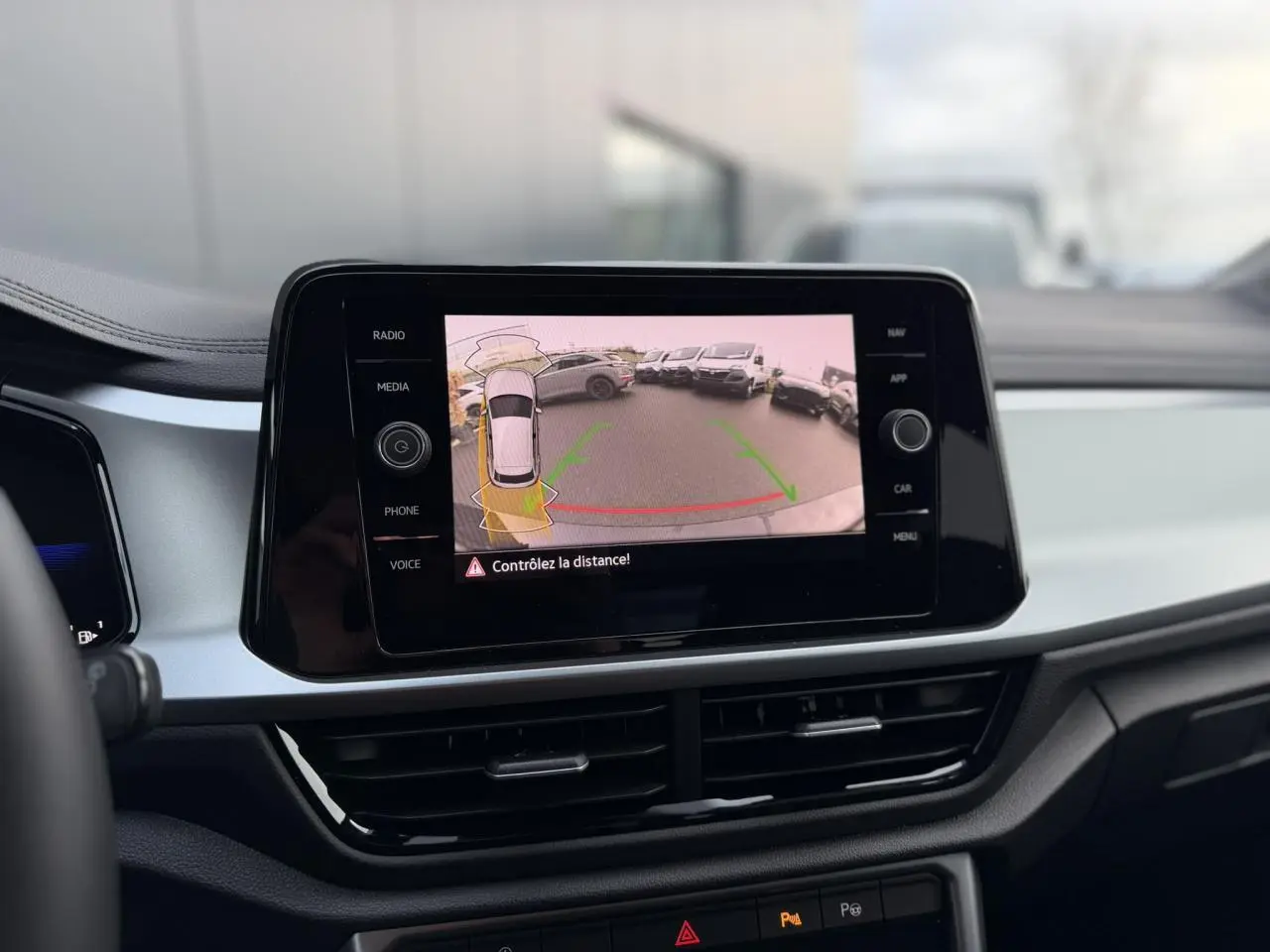 Vue intérieure du tableau de bord du Volkswagen T-Roc 1.5 TSI 150 DSG Life 30 Years avec écran tactile affichant la caméra de recul.