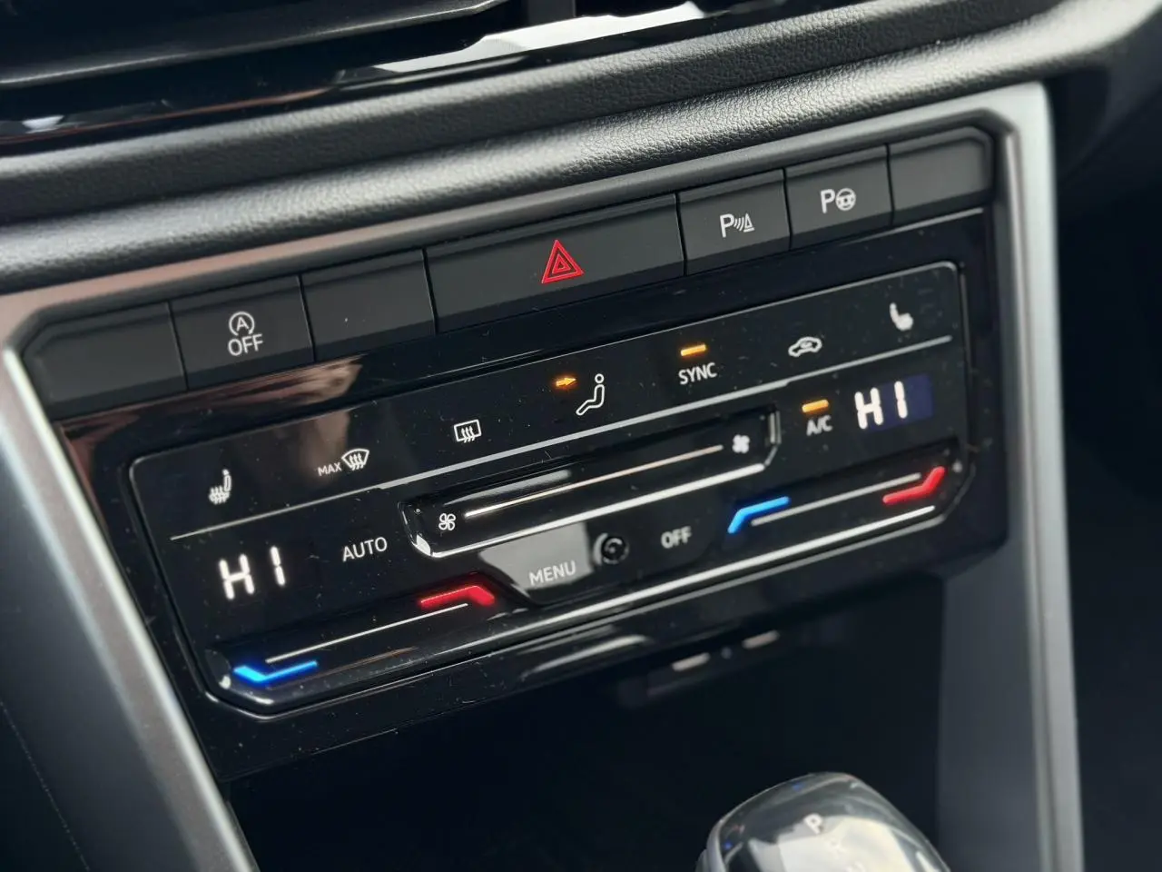 Gros plan sur la console centrale du Volkswagen T-Roc 1.5 TSI 150 DSG Life 30 Years, montrant la climatisation automatique bi-zone et les commandes chauffantes.