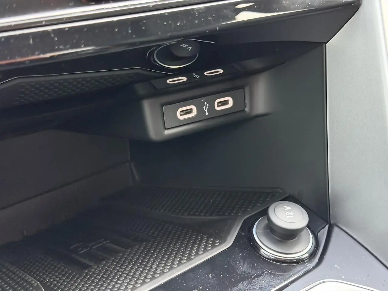 Gros plan sur la console centrale du Volkswagen T-Roc 2025, montrant prises USB-C et prise 12V noire.