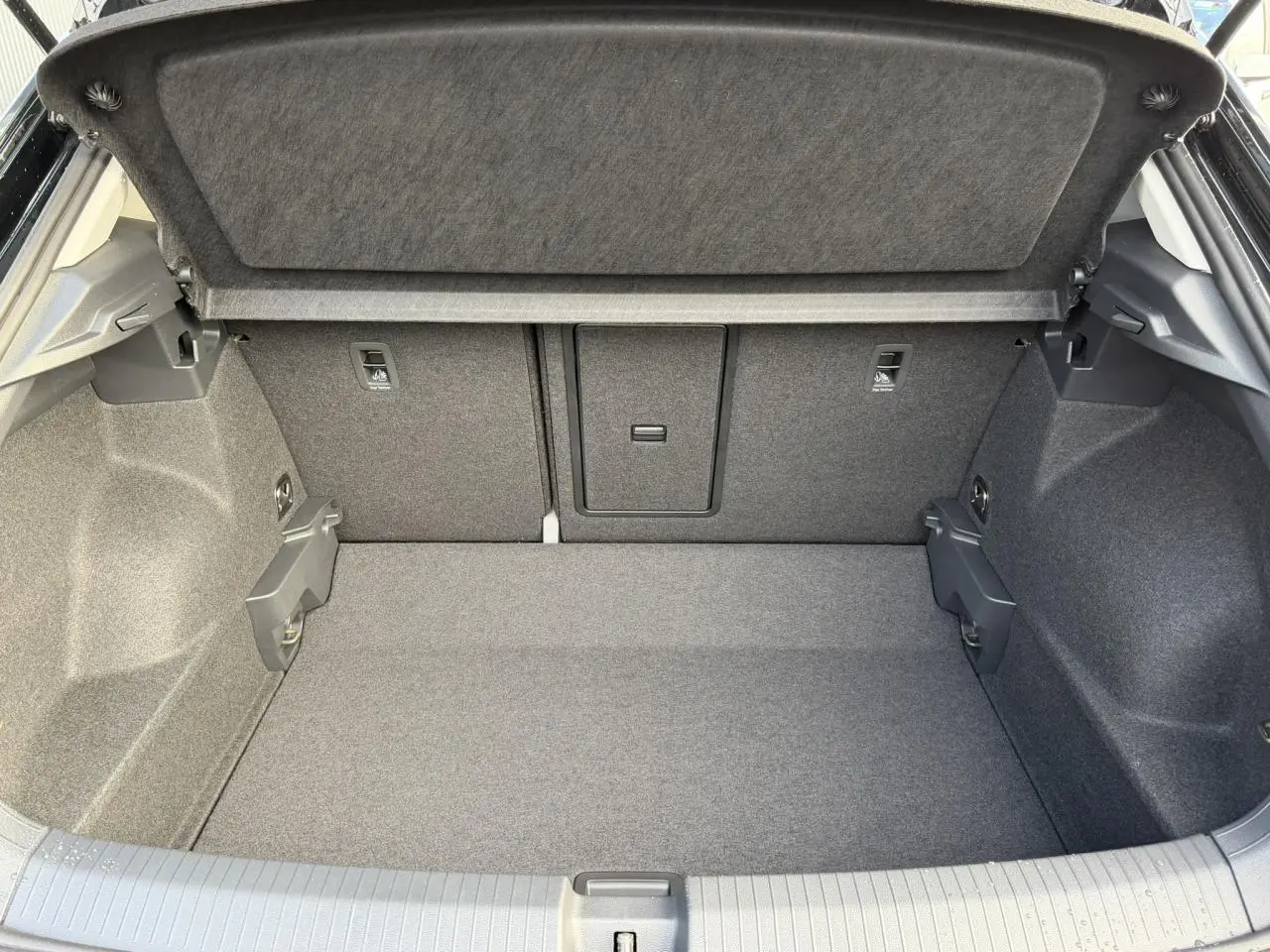 Coffre ouvert du Volkswagen T-Roc Deep Black 2025, montrant un espace de chargement propre et bien agencé.