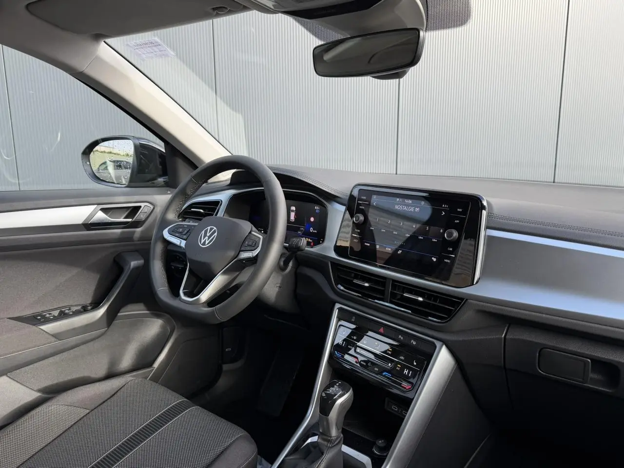 Vue intérieure côté conducteur du Volkswagen T-Roc 1.5 TSI 150 DSG Life 30 Years avec tableau de bord moderne et écran tactile.