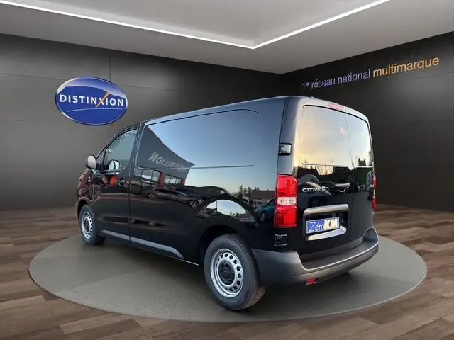 Vue 3/4 arrière droite d'un Citroën Jumpy noir Perla Nera métal, fourgon fermé avec double portes arrière et jantes acier.