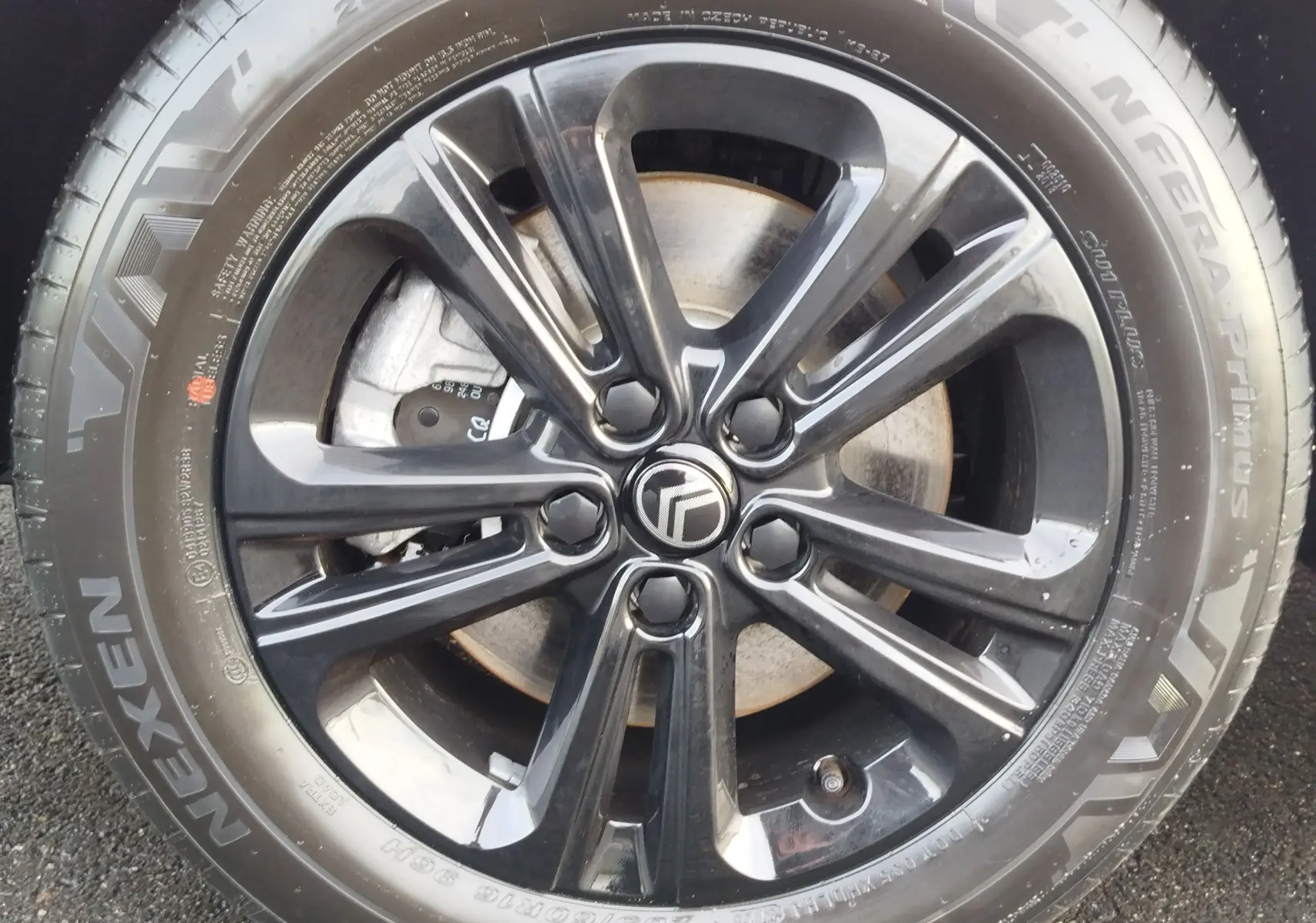 Gros plan sur la jante noire brillante avec logo Citroën, montée sur un pneu Nexen N'Fera Primus.