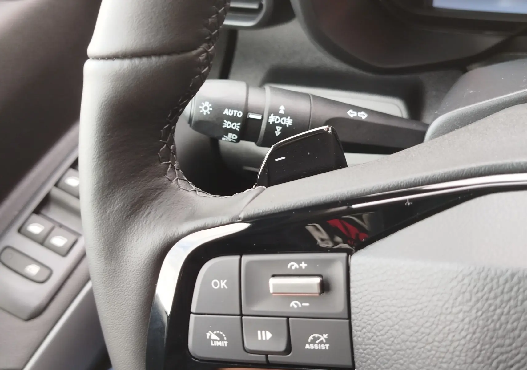 Gros plan sur la partie gauche du volant noir du Citroën Berlingo 2025 avec commandes intégrées et levier de clignotant.