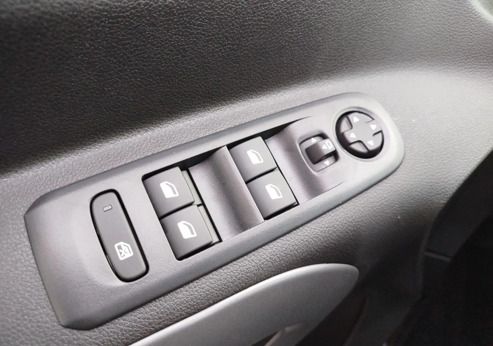 Gros plan sur les commandes de lève-vitres et rétroviseurs côté gauche du Citroën Berlingo 2025 en Kaolin White.