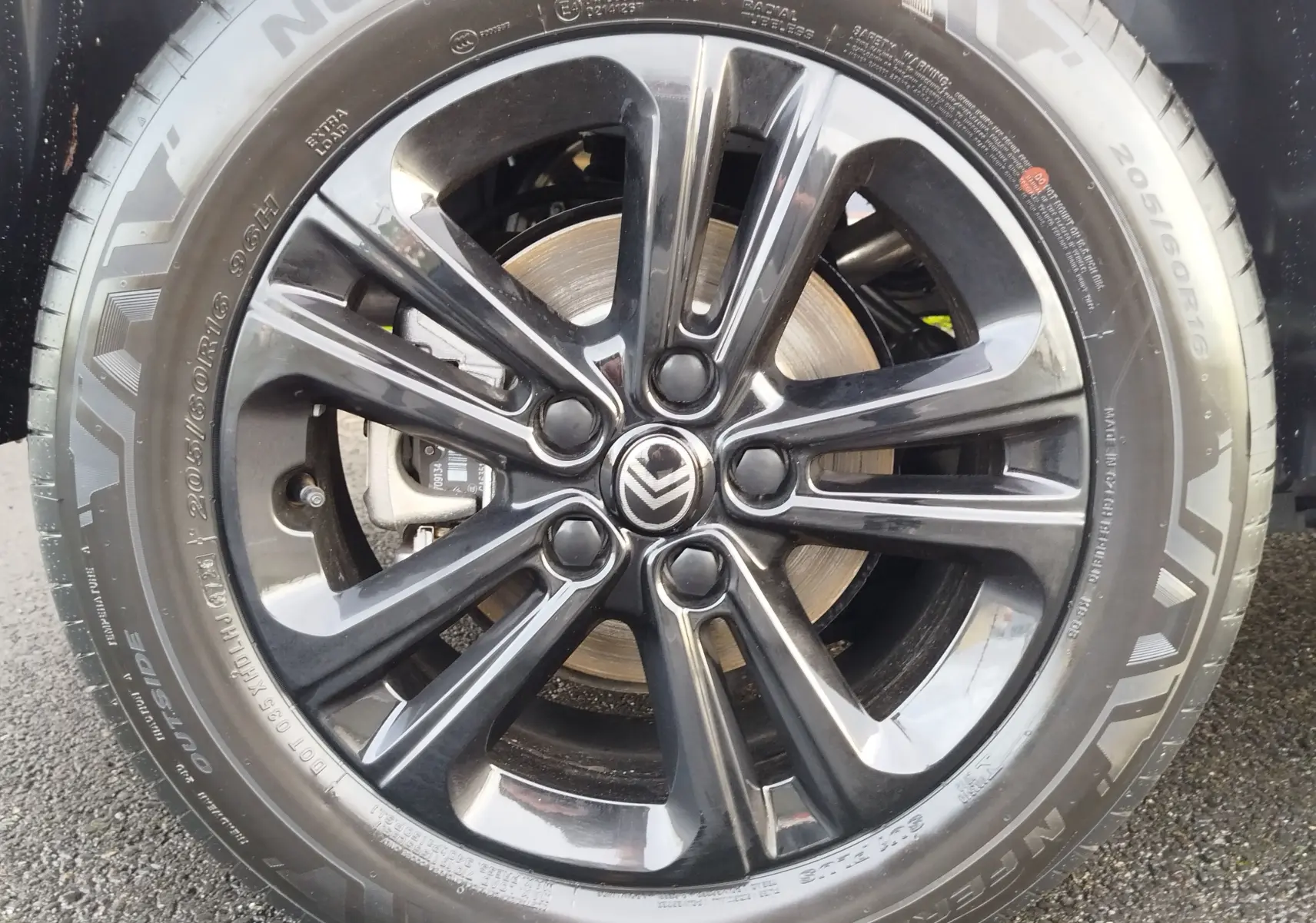 Gros plan sur la jante noire brillante de 16 pouces avec logo Citroën, montée sur un pneu Nexen 205/60 R16.