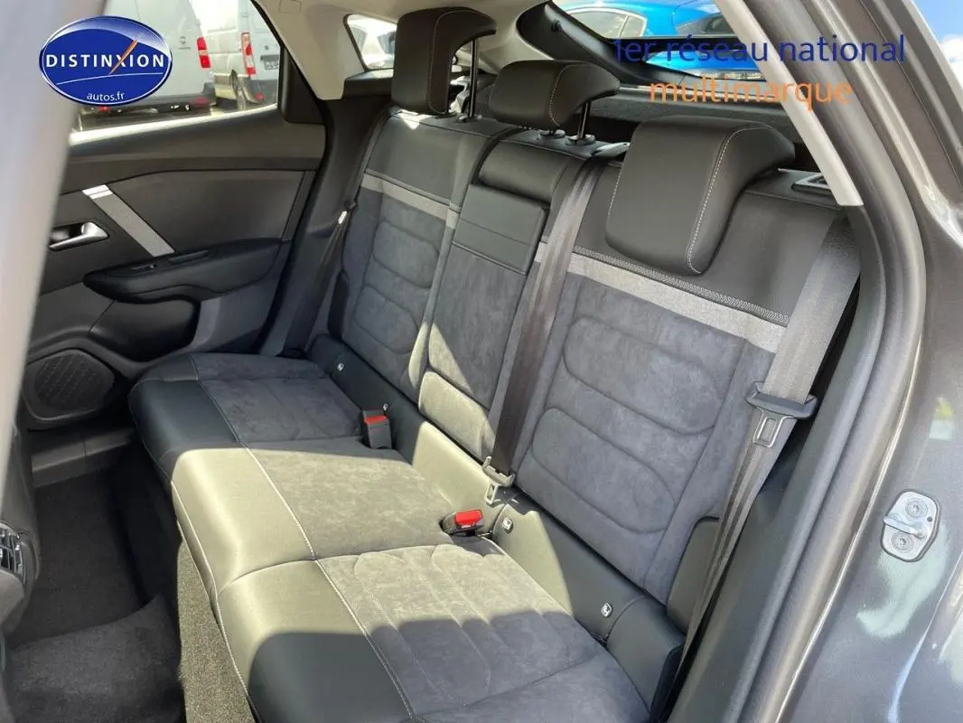 Vue intérieure côté gauche des sièges arrière en tissu et cuir gris sur Citroën C4 platine 2024 avec ceinture de sécurité visible.