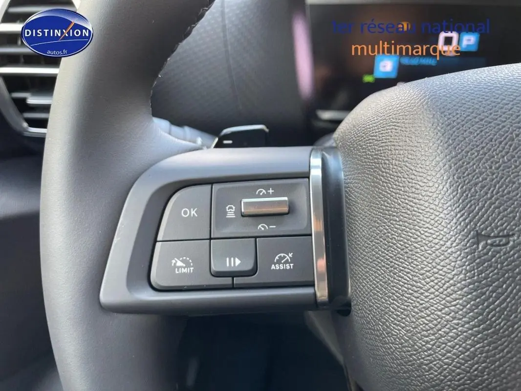 Gros plan sur les commandes au volant cuir noir de la Citroën C4 platine 2024 avec régulateur et assistant de conduite.