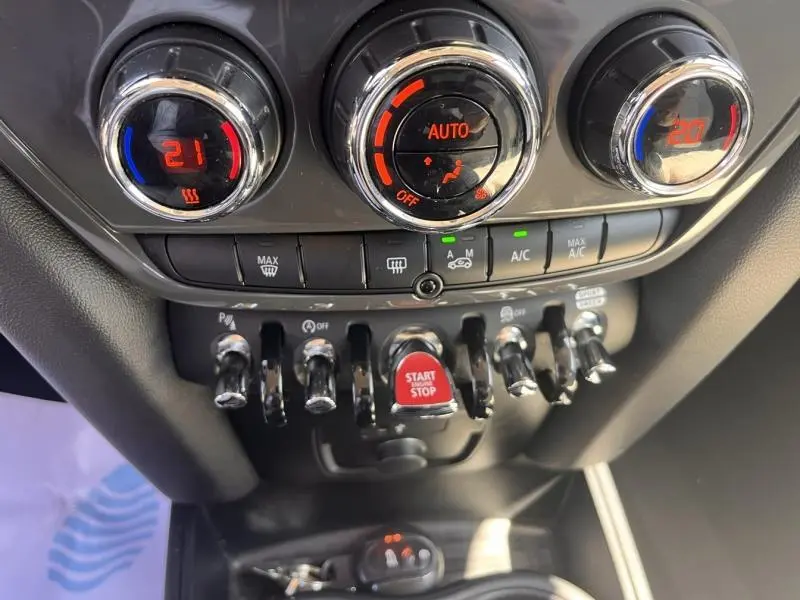 Gros plan sur la console centrale du MINI Countryman Cooper D 2018, montrant les commandes de climatisation et le bouton Start/Stop rouge.