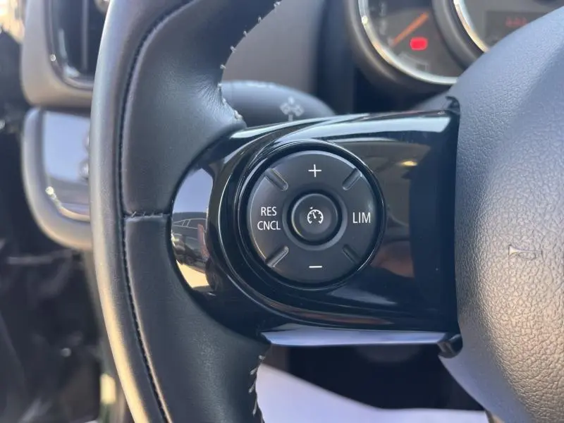 Gros plan sur le bouton de régulateur de vitesse noir sur le volant cuir du MINI Countryman Cooper D 2018.