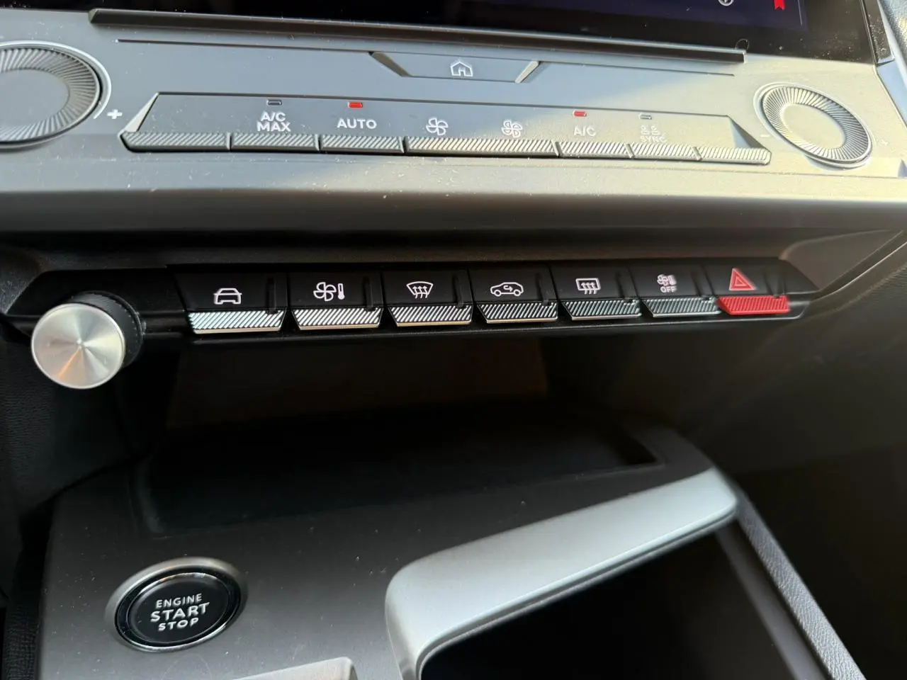 Vue rapprochée du tableau de bord de la Peugeot 308 2025 noir Perla, montrant les commandes climatisation et bouton start/stop.