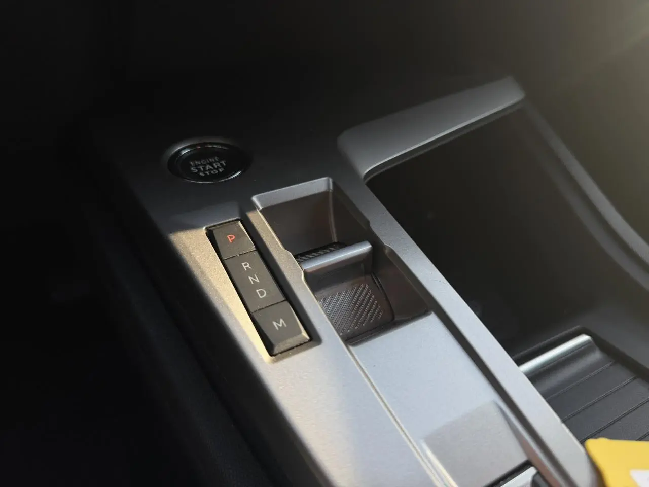 Gros plan sur la console centrale de la Peugeot 308 2025, montrant la commande de boîte auto et le bouton start/stop.