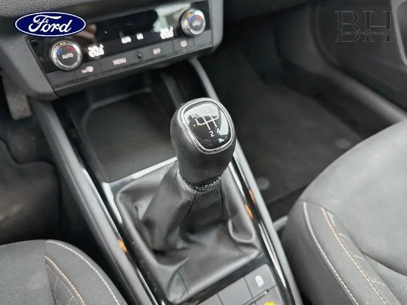 Gros plan sur le levier de vitesses manuel noir dans l'habitacle d'une Skoda Kamiq Gris Météore, avec console centrale visible.