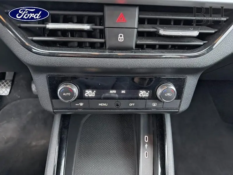 Vue rapprochée de la console centrale du Skoda Kamiq gris Météore, mettant en valeur la climatisation automatique bi-zone.