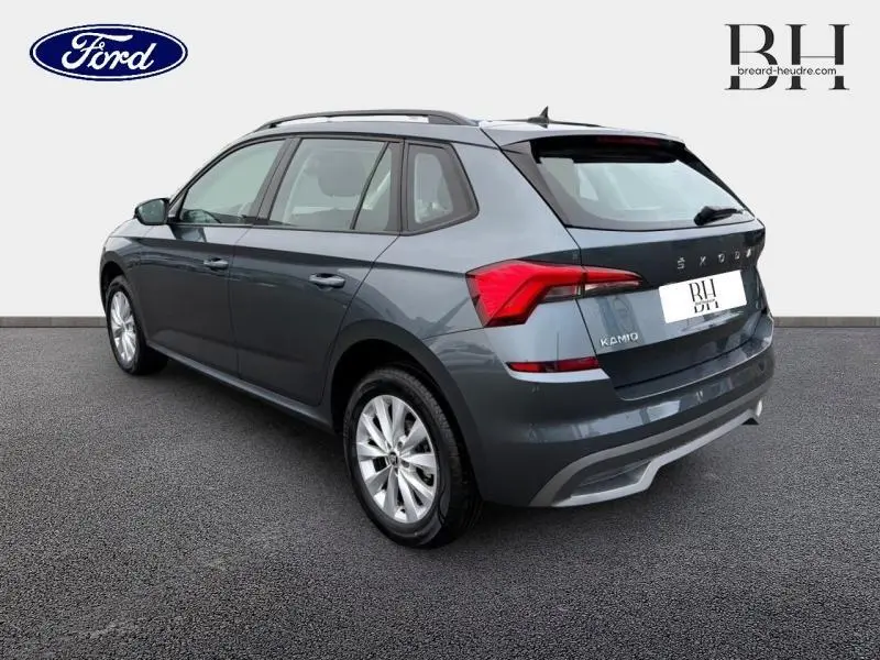 Vue 3/4 arrière droite d'un Skoda Kamiq gris météore avec jantes alu et feux arrière LED distinctifs.