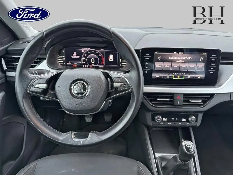Vue intérieure centrée sur le volant cuir et l'écran tactile du tableau de bord du Skoda Kamiq 2021 gris Météore.